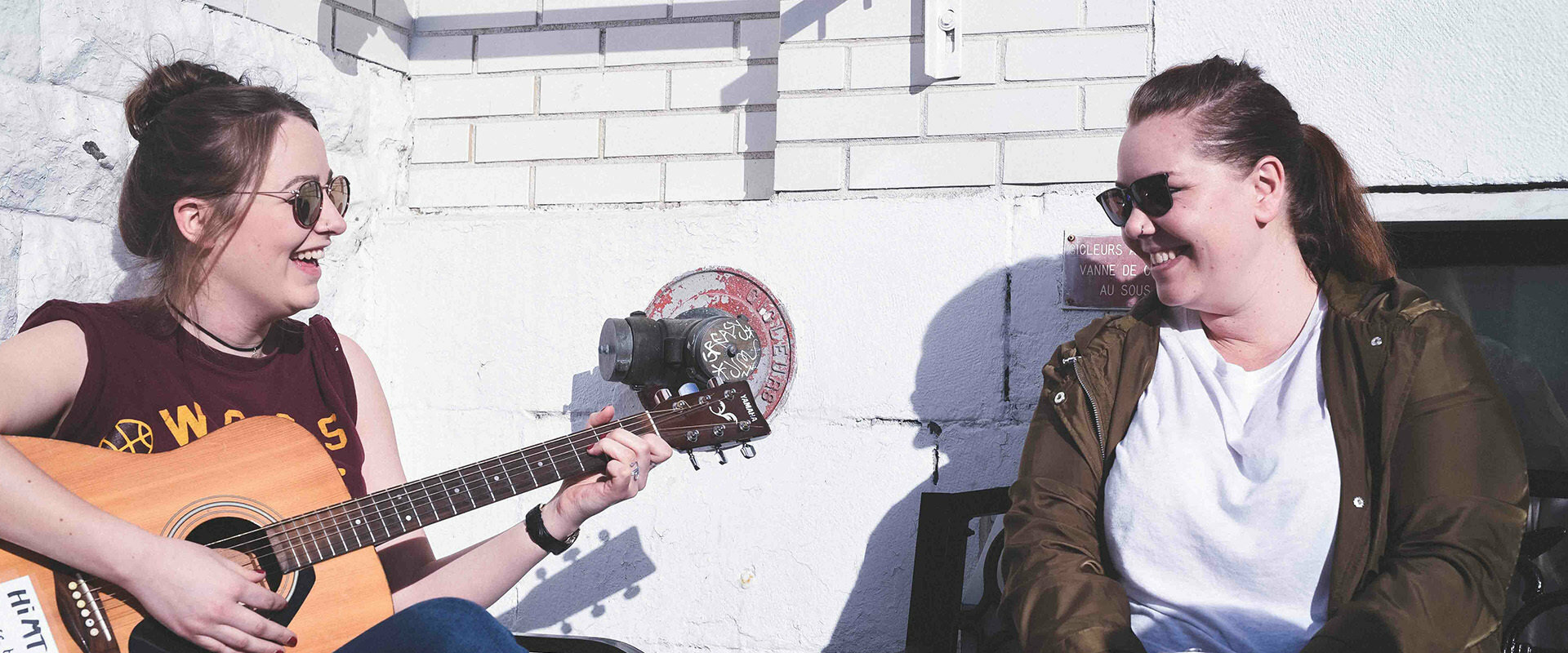 Girls playing the guitar outside an hostel